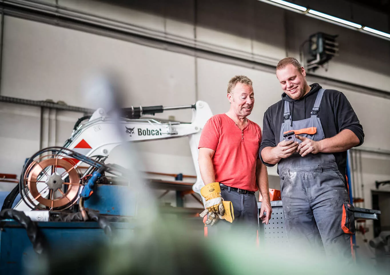 Zwei Mitarbeiter der Dasenbrock Rohr- und Kabelverlegung GmbH schauen gemeinsam auf ein Handy
