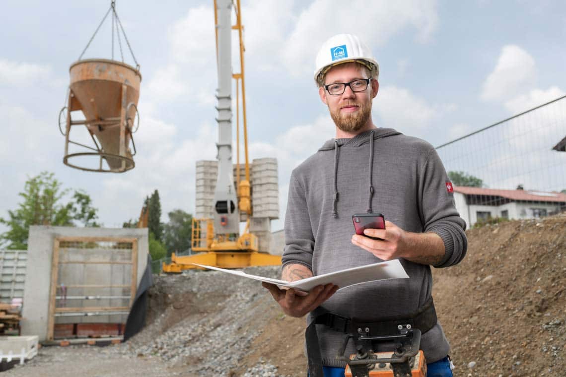 Kranführer von der Baugeschäft H & M GmbH auf der Baustelle mit seinem Handy