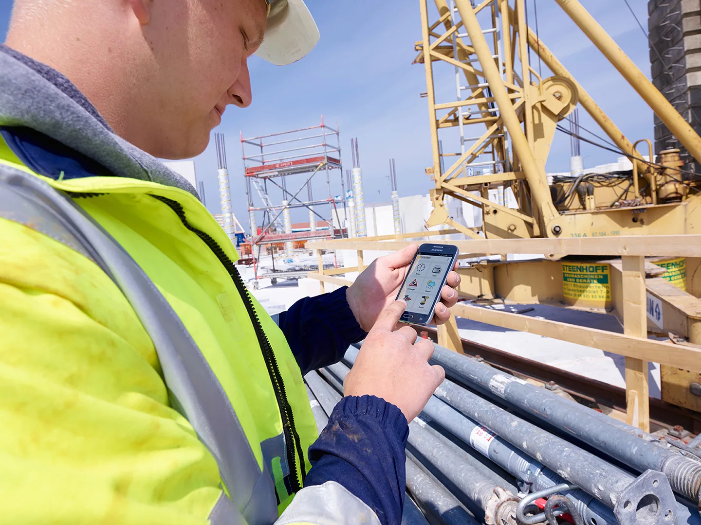 Mitarbeiter der Tell Bau GmbH mit der mobilen 123erfasst App auf seinem Handy
